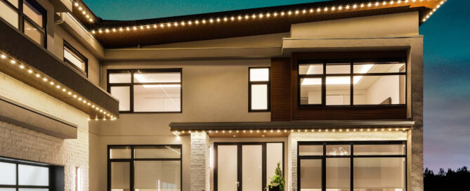 Warm white permanent Christmas lights on a Greater Cincinnati home — track-mounted system controlled from a phone.