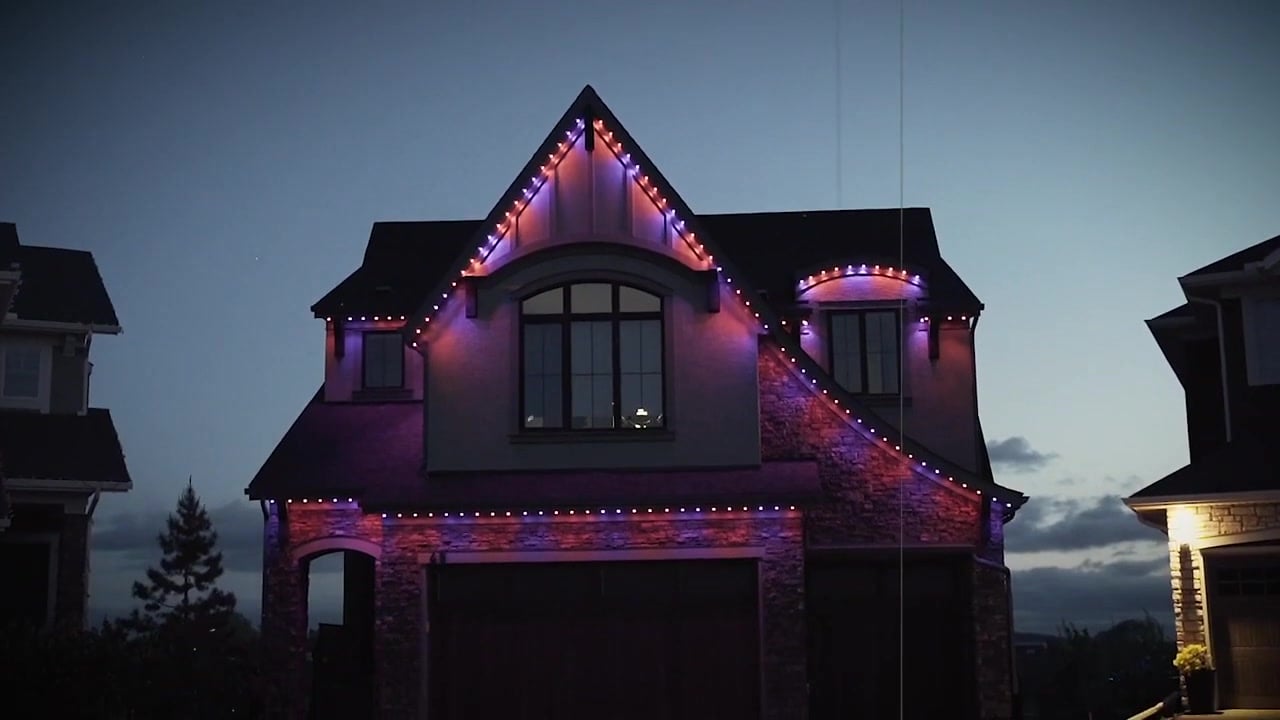 Permanent Gemstone lights showing purple and orange Halloween colors on a home exterior.