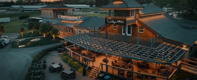 Warm white permanent outdoor lighting along a Cincinnati-area home roofline at dusk.