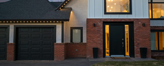 Warm white permanent lighting along the gable and garage eaves of a modern home at dusk — example from an authorized Gemstone dealer gallery.