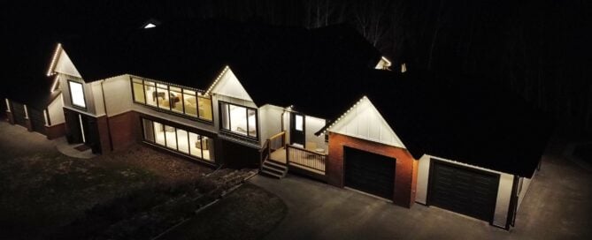Warm white permanent lights along the front roofline, entry peaks, and garage gable of a home at night — example from an authorized Gemstone dealer gallery.
