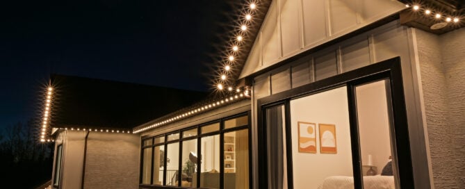 Warm-white permanent roofline lighting on a modern home — authorized Gemstone dealer example.