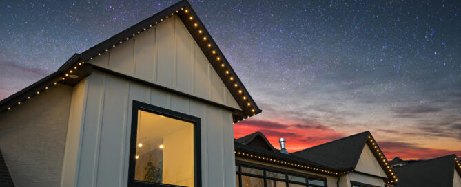 Warm white permanent lighting tracing a gable roofline at dusk — example from an authorized Gemstone dealer gallery.