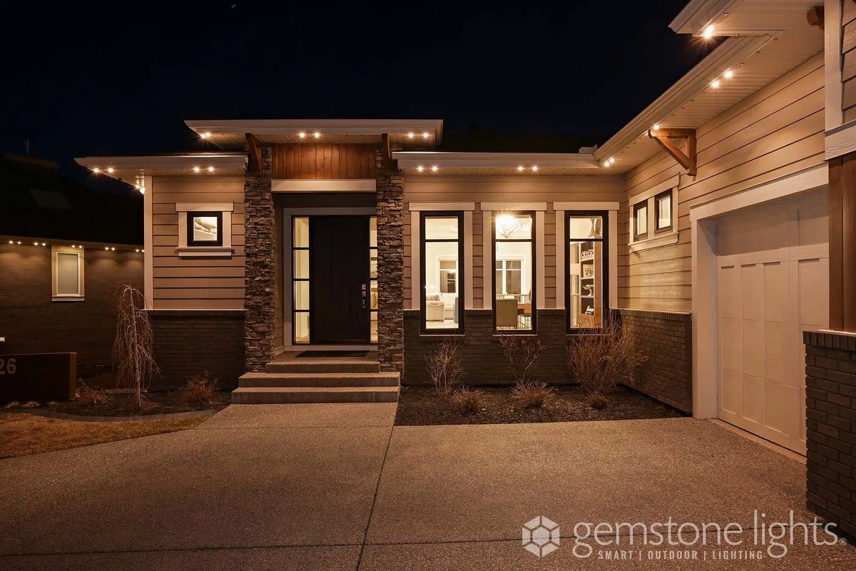Contemporary single-story home with Gemstone permanent lighting in warm white along the soffits at night